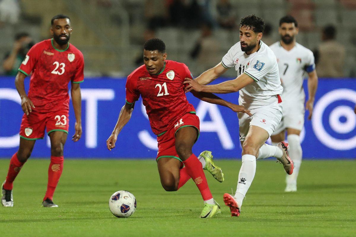 Palestine's Oday Dabbagh in action with Oman's Abdulrahman Al-Mushaifri during their match at King Abdullah II Stadium, Amman, Jordan
