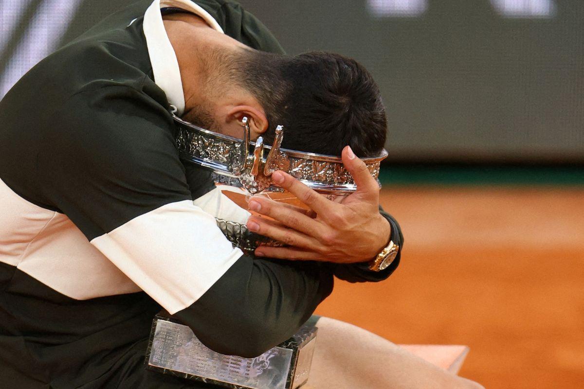Spain's Carlos Alcaraz celebrates with the trophy after winning the men's singles final against Italy's Jannik Sinner in the French Open final, in Paris, on June 8