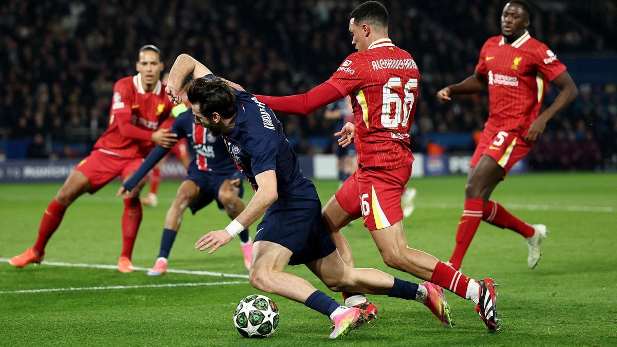 Paris St Germain's Khvicha Kvaratskhelia is challenged by a host of Liverpool defenders as he tries to break through.