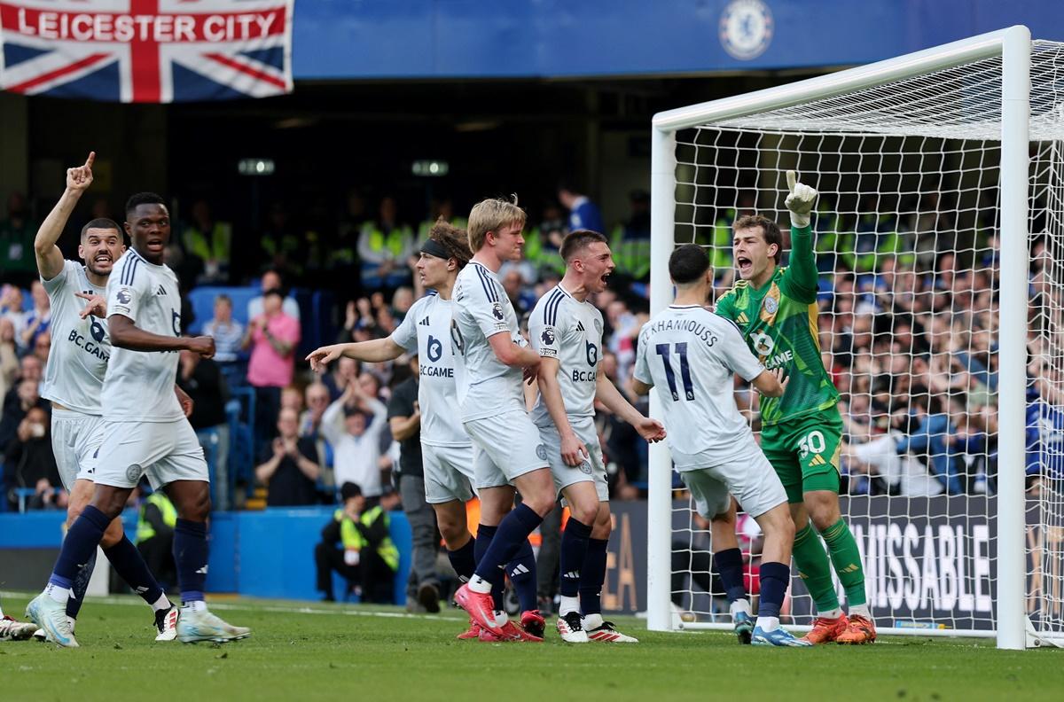 Leicester City goalkeeper Mads Hermansen celebrates with teammates after saving a penalty from Chelsea's Cole Palmer.