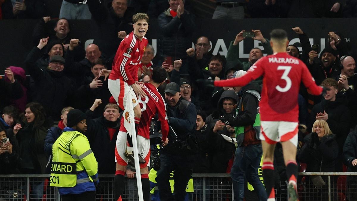 Bruno Fernandes celebrates with teammates after scoring Manchester United's third goal and completing his hat-trick.