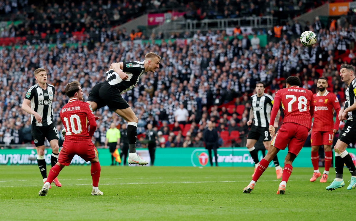 Newcastle United's Dan Burn scores their first goal against Liverpool in their League Cup win on Sunday