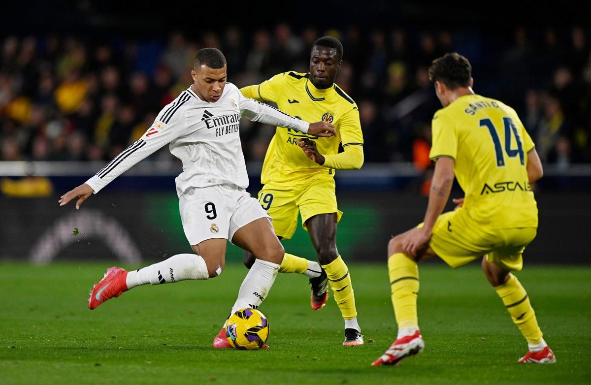 Kylian Mbappe is challenged by Villarreal's Pape Gueye and Santi Comesana as he prepares to strike at goal.