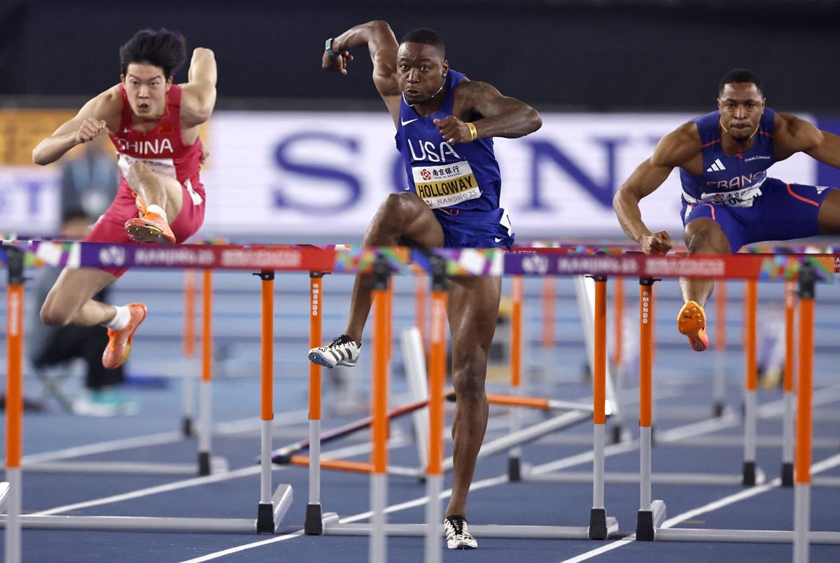 Grant Holloway of the United States, France's Wilhem Belocian and China's Weibo Qin in action during the men's 60 metres Hurdles final.