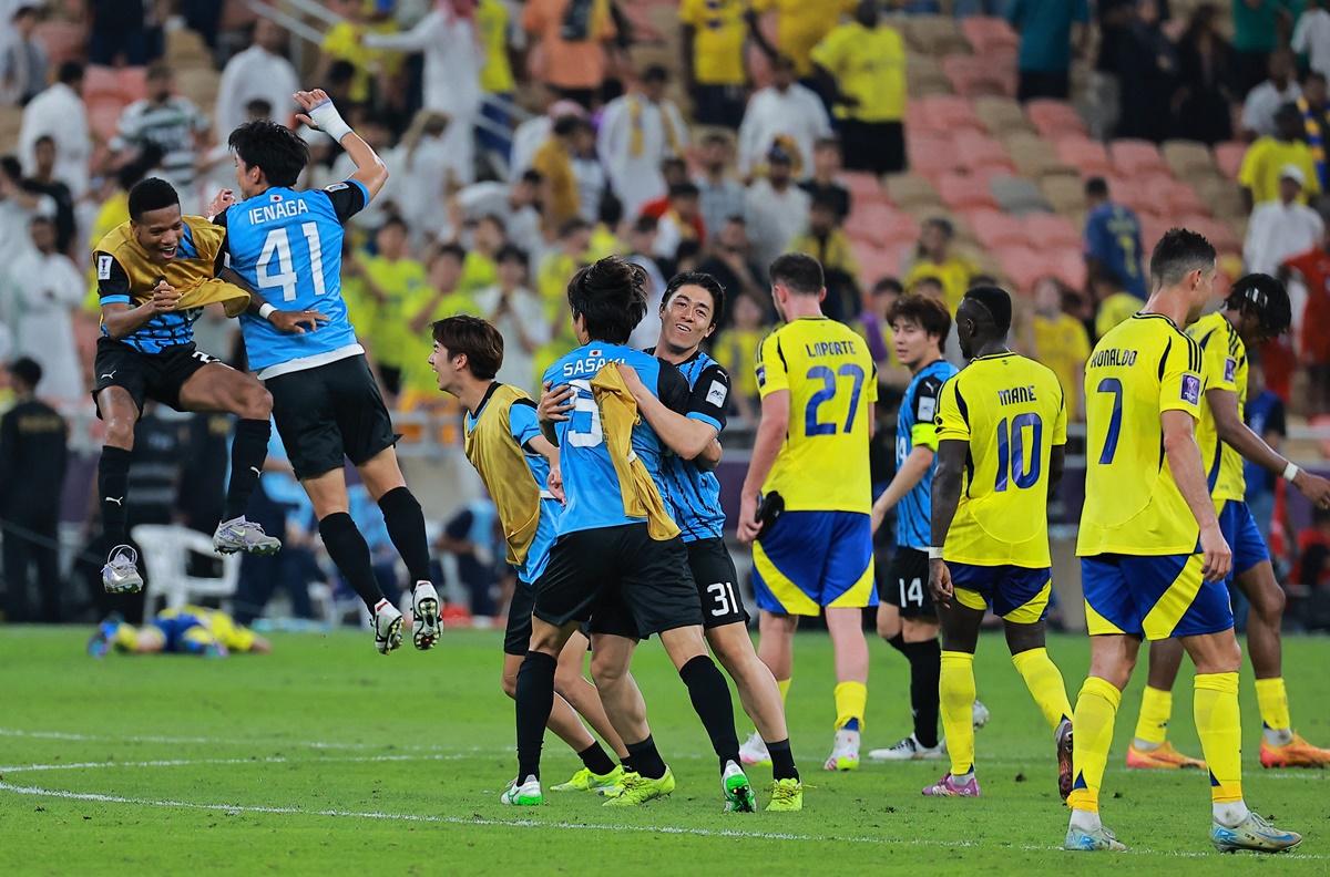 Kawasaki Frontale's Sai Van Wermeskerken and Asahi Sasaki celebrate with teammates as Al Nassr's players walk back after the match.