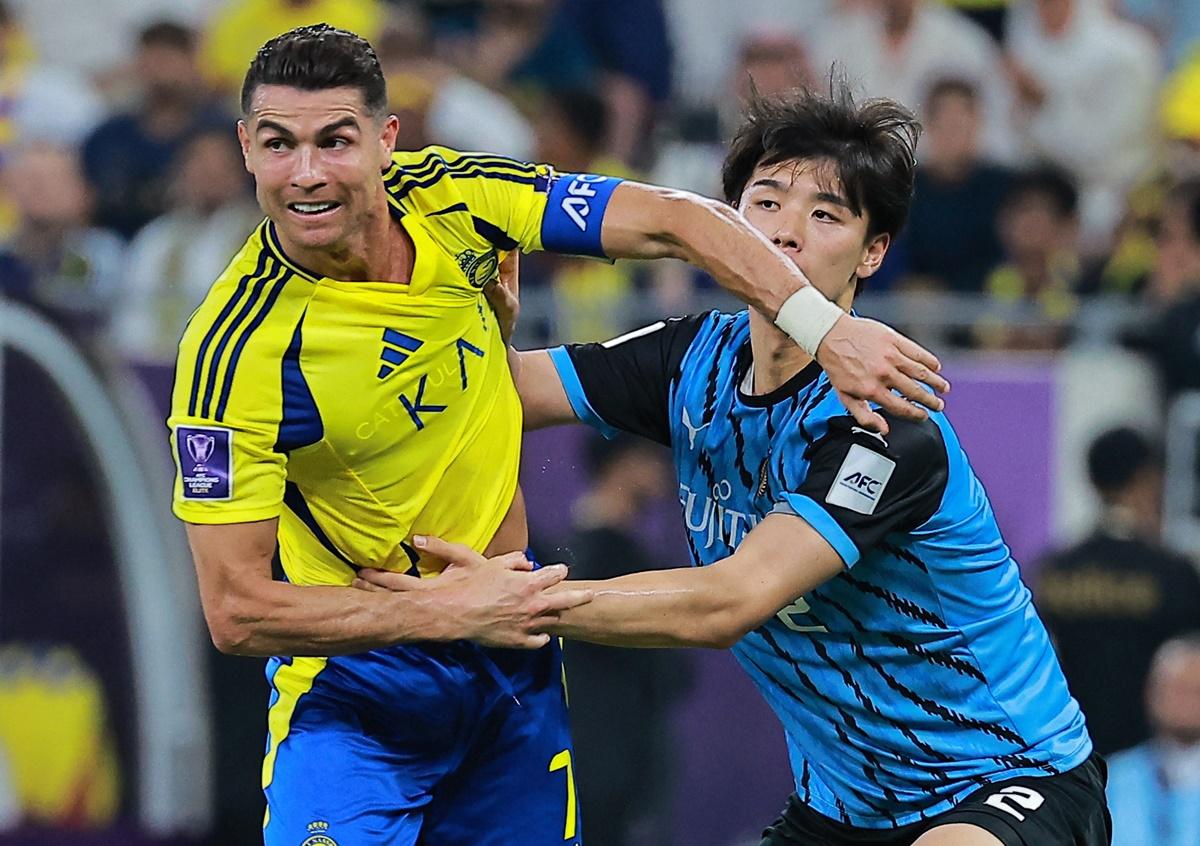 Kawasaki Frontale's Kota Takai tries to prevent Cristiano Ronaldo from breaking through.