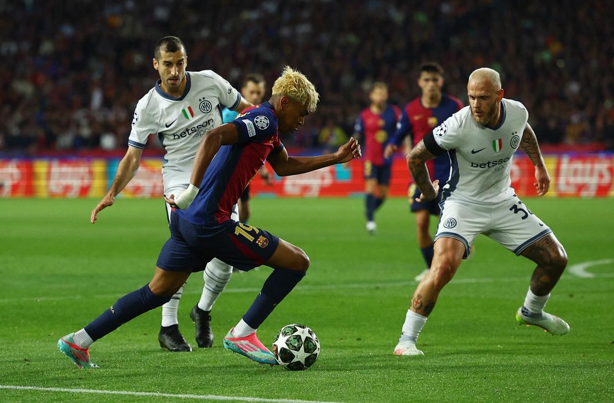Lamine Yamal tries to get past Inter Milan's Henrikh Mkhitaryan and Federico Dimarco.