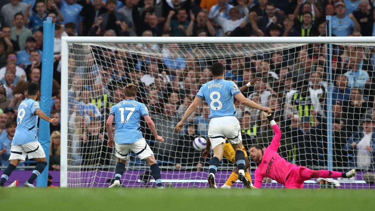 Manchester City's Kevin De Bruyne sends the ball past Wolverhampton Wanderers goalkeeper Jose Sa in the Premier League match at Etihad Stadium, Manchester, on Friday.