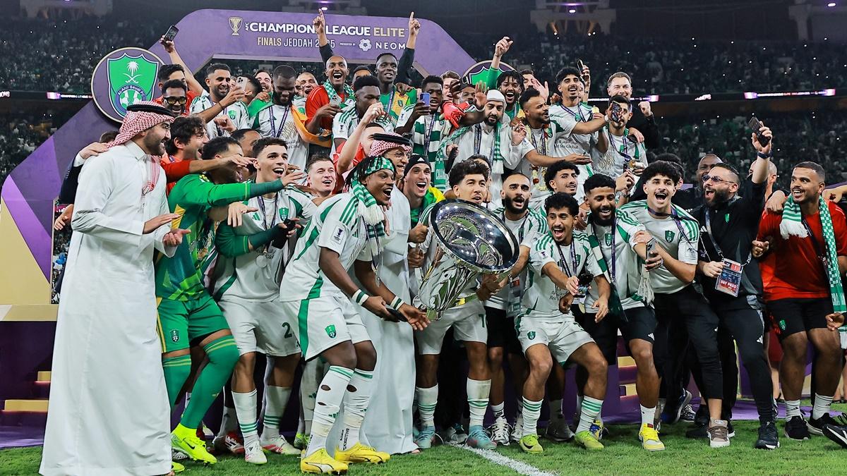 Al Ahli's Roberto Firmino lifts the trophy as he celebrates with teammates.