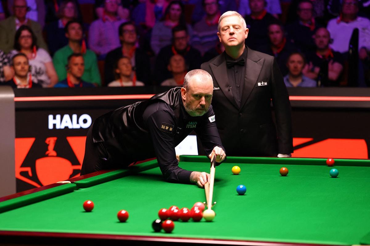 Judd Trump watches anxiously as Mark Williams goes about clearing the table on course to his second century clearance of the day.