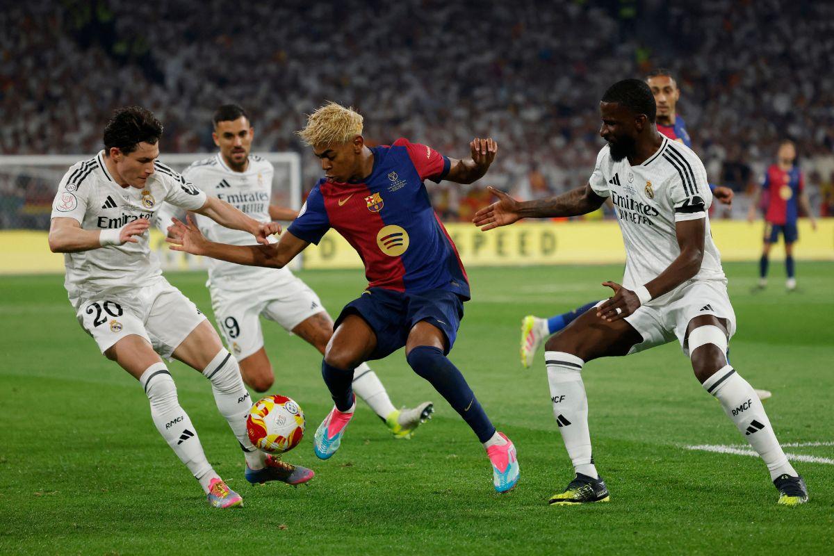 FC Barcelona's Lamine Yamal is challenged by Real Madrid players 