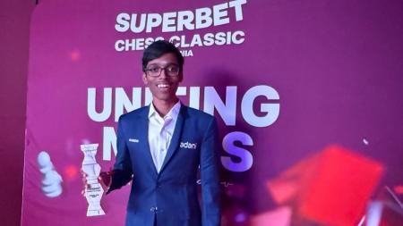 R Praggnanandhaa poses with the trophy after winning the Superbet Chess Classic