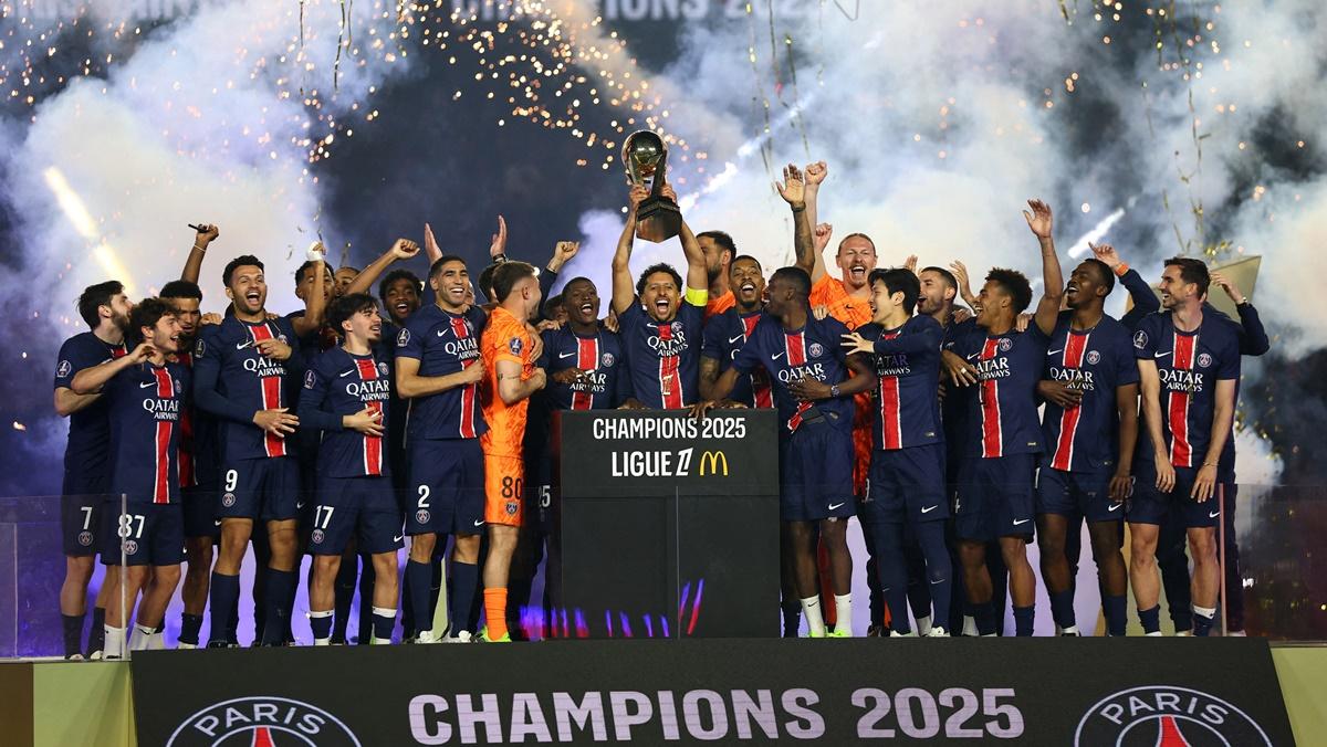 Paris St Germain's Marquinhos lifts the trophy as he celebrates with teammates after winning Ligue 1, at Parc des Princes, Paris, on Saturday.