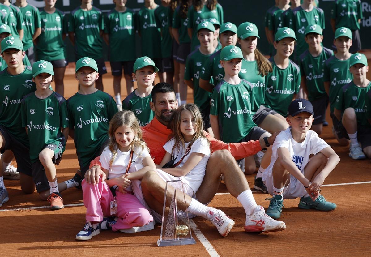 Novak Djokovic poses with the trophy, his children and ball kids after the final.