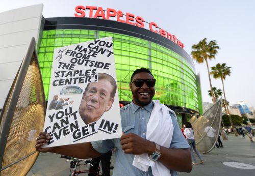 Protester holds a sign in front of the Staples Center in Los Angeles, 